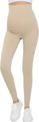 Wholesale beige maternity leggings with high waistband and side pocket detail, styled with white sneakers